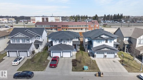 Modern two-story residence with a light-colored facade, dark shingled roof, and white trim accents - 21722 99A Avenue Nw, Edmonton, AB - Outdoor With Facade