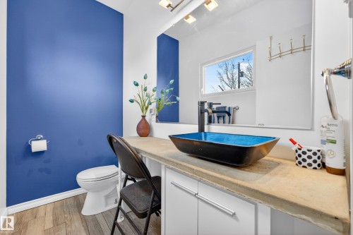 Bathroom featuring a vessel sink with a dark blue interior, a single-handle matte black faucet, and a light-toned countertop - 5304 90A Avenue, Edmonton, AB 
