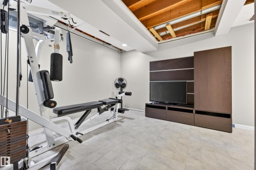 Recreational space featuring a built-in media center with dark wood-finish cabinetry, recessed ceiling lighting, and light-colored flooring - 5304 90A Avenue, Edmonton, AB 