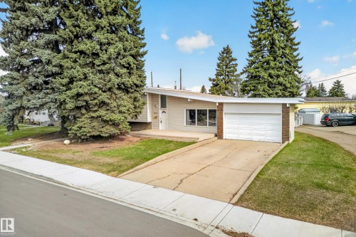 Exterior featuring a single-car garage, partial brick facade, and an asphalt driveway - 5304 90A Avenue, Edmonton, AB 