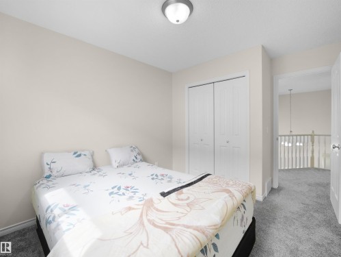 Carpeted room featuring a ceiling-mounted light fixture, bi-fold closet doors, and light-toned wall paint - 7407 Singer Landing Landing, Edmonton, AB - Indoor Photo Showing Bedroom