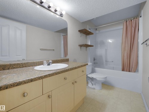 Bathroom featuring a light-toned vanity with stone-look countertop and an integrated sink - 7407 Singer Landing Landing, Edmonton, AB - Indoor Photo Showing Bathroom