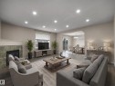 Spacious living area featuring wood-finish flooring, recessed lighting, and a tiled fireplace - 7407 Singer Landing Landing, Edmonton, AB  - Indoor Photo Showing Living Room With Fireplace 