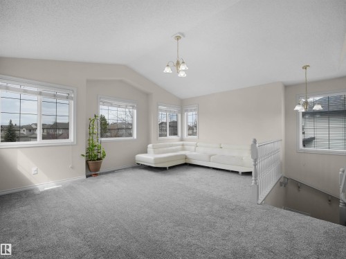 Spacious room with vaulted ceilings and abundant natural light from multiple windows - 7407 Singer Landing Landing, Edmonton, AB - Indoor