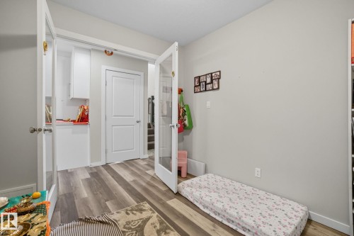 Room featuring wood-finish flooring, light grey wall paint, and white trim - 2039 Wonnacott Way, Edmonton, AB 
