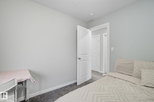 Interior room featuring light gray wall paint, white trim, and dark gray carpeting - 2039 Wonnacott Way, Edmonton, AB 