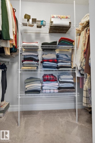 This closet features a practical wire shelving system and light-colored carpeting - 1014 162 St Sw, Edmonton, AB - Indoor With Storage