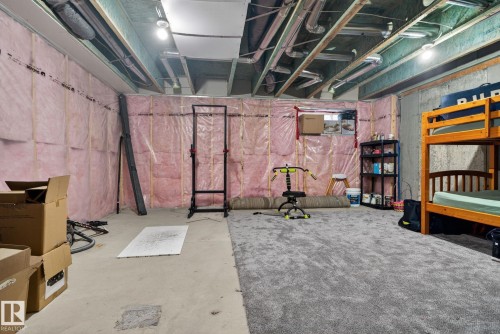 The property features an unfinished basement with exposed insulation, concrete walls, and overhead ductwork - 1014 162 St Sw, Edmonton, AB - Indoor Photo Showing Basement