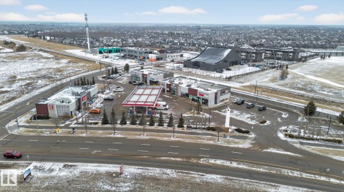 This aerial view highlights the property's advantageous location within a commercial area, featuring several retail and service establishments - 1014 162 St Sw, Edmonton, AB - Outdoor With View