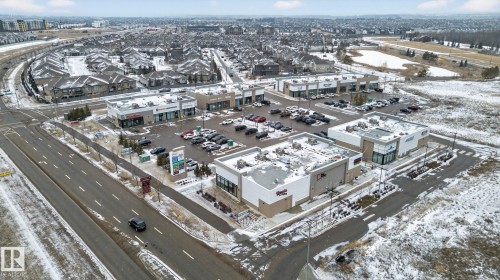 Aerial view showcasing several commercial buildings with parking areas, surrounded by roads and a residential neighborhood - 1014 162 St Sw, Edmonton, AB -  With View