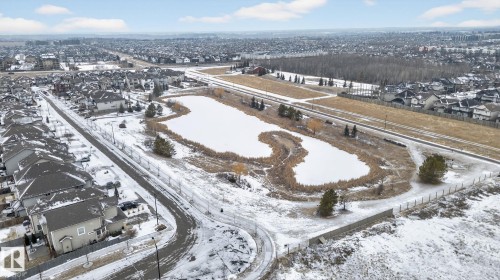 Aerial view of the surrounding neighbourhood featuring residential properties, a frozen pond, and walking paths - 1014 162 St Sw, Edmonton, AB - Outdoor With View
