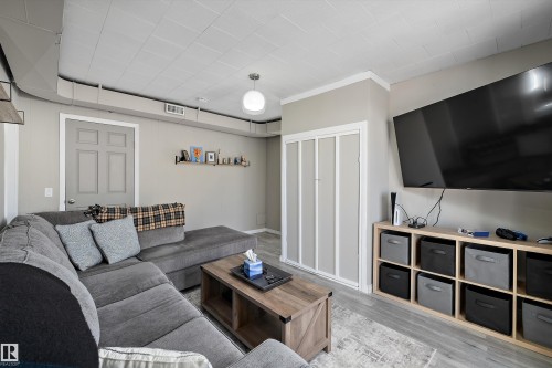 Living area featuring wood-finish flooring, light gray wall paint, and a ceiling-mounted light fixture - 4908 49 Avenue, Onoway, AB - Indoor Photo Showing Living Room