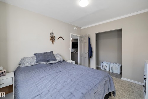 Bedroom featuring neutral wall paint, white trim, recessed closet, wood-finish flooring, and a flush-mount ceiling light - 4908 49 Avenue, Onoway, AB - Indoor Photo Showing Bedroom
