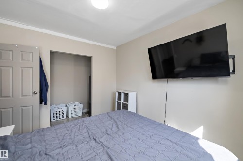 Bedroom featuring light neutral wall paint, white crown molding, and an open closet - 4908 49 Avenue, Onoway, AB - Indoor Photo Showing Bedroom