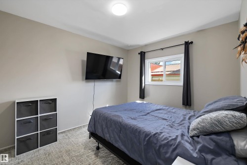 Bedroom featuring a single window with dark drapery, light-toned walls, and textured carpet flooring - 4908 49 Avenue, Onoway, AB - Indoor Photo Showing Bedroom