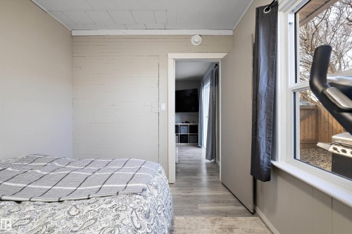 Interior space featuring wood-finish flooring, light-toned walls, and a window providing exterior visibility - 4908 49 Avenue, Onoway, AB - Indoor Photo Showing Bedroom