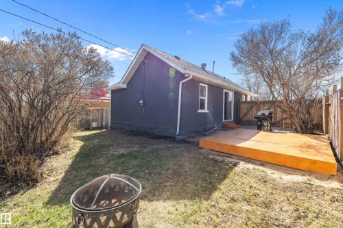 Rear exterior featuring a recently constructed wooden deck, dark gray siding, and a fenced perimeter - 4908 49 Avenue, Onoway, AB - Outdoor