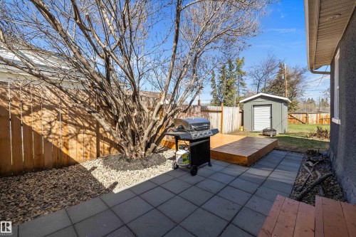 Paved patio area with a wood deck, gravel landscaping, and a privacy fence - 4908 49 Avenue, Onoway, AB - Outdoor