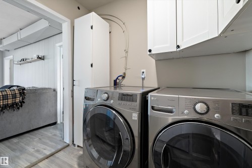 Dedicated laundry area featuring white upper cabinetry, a tall built-in storage cabinet, and neutral wall tones - 4908 49 Avenue, Onoway, AB - Indoor Photo Showing Laundry Room
