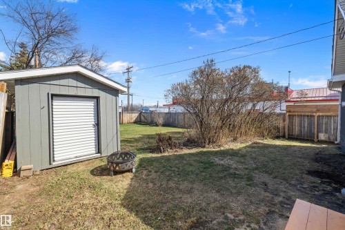 Spacious backyard featuring a storage shed with a roll-up door, a privacy fence, and a mature shrub - 4908 49 Avenue, Onoway, AB - Outdoor