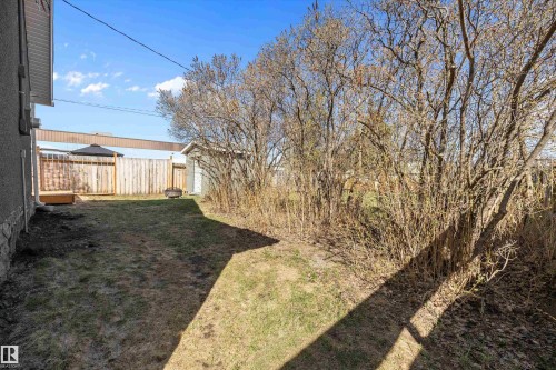 Expansive backyard featuring a wood privacy fence, a wood deck, and a detached shed - 4908 49 Avenue, Onoway, AB - Outdoor