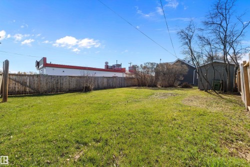 Expansive grassy yard with wooden perimeter fencing - 4908 49 Avenue, Onoway, AB - Outdoor
