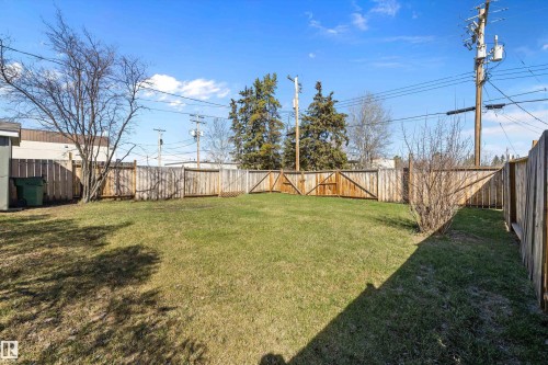 Expansive backyard featuring a manicured lawn, established perimeter fencing, and mature trees - 4908 49 Avenue, Onoway, AB - Outdoor