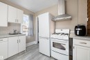 Kitchen featuring white cabinetry, wood-finish flooring, a stainless steel range hood, subway tile backsplash, and a white gas range with oven - 4908 49 Avenue, Onoway, AB  - Indoor Photo Showing Kitchen 