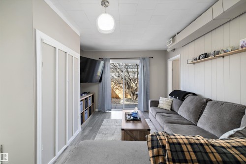 Living area featuring wood-finish flooring and a white paneled accent wall - 4908 49 Avenue, Onoway, AB - Indoor Photo Showing Other Room