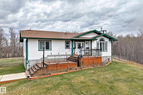 White siding exterior with a brown shingle roof and green trim - 8 54514 Rr12, Rural Lac Ste. Anne County, AB - Outdoor With Deck Patio Veranda