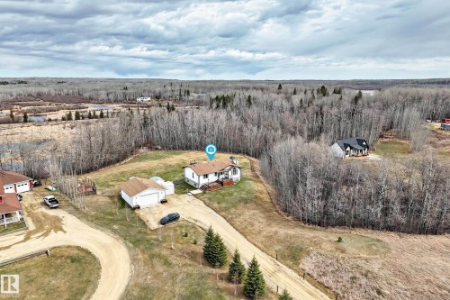 Aerial perspective showcasing a single-family home with a detached garage, surrounded by extensive wooded acreage - 8 54514 Rr12, Rural Lac Ste. Anne County, AB - Outdoor With View