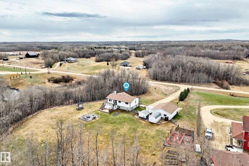 Aerial perspective showcasing a property featuring a multi-level home with a brown shingled roof, a rear deck, and an expansive yard - 8 54514 Rr12, Rural Lac Ste. Anne County, AB - Outdoor With View