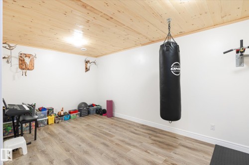 Spacious room featuring wood-finish flooring and a natural wood plank ceiling - 6864 Evans Wynd, Edmonton, AB - Indoor Photo Showing Other Room