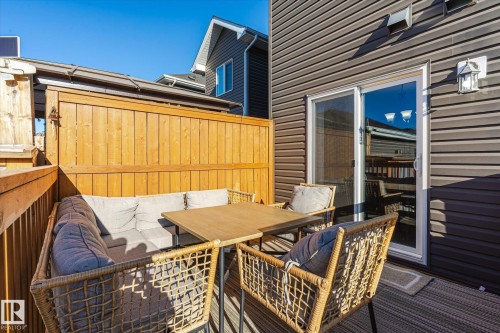 Outdoor deck featuring wood privacy fencing, a sliding glass door, and exterior siding - 6864 Evans Wynd, Edmonton, AB - Outdoor