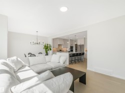 Open concept living space with light wood flooring and recessed lighting - 