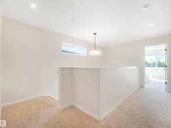 The property features neutral-toned carpet, recessed lighting, and a modern ceiling light fixture - 