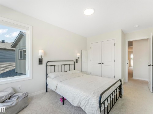 This room features light-colored carpet, a window providing natural light, and a ceiling light fixture - 19 Nettle Crescent, St. Albert, AB - Indoor Photo Showing Bedroom