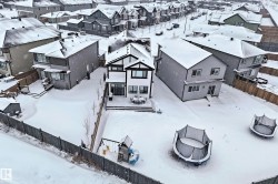 The property features a two-story exterior with a deck, a fenced yard, and a paved street - 