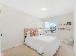 This room features light-colored carpeting, a window providing natural light, and a ceiling light fixture - 