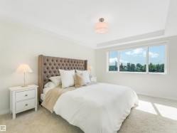 This inviting space features a large window, light-colored carpet, and a modern ceiling light fixture - 