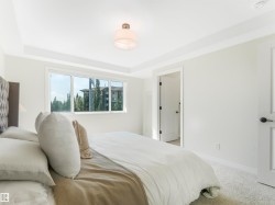 The property features a bright room with a large window, white walls, and a ceiling light fixture - 