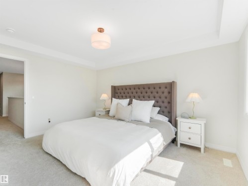 This bright room features neutral-toned carpeting, a large window providing natural light, and a ceiling light fixture - 19 Nettle Crescent, St. Albert, AB - Indoor Photo Showing Bedroom