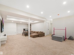 Spacious room featuring light-colored carpeting, recessed lighting, and white walls - 