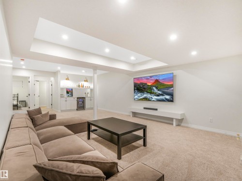 The room features recessed lighting, a built-in media console, and a wet bar with white cabinetry and shelving - 19 Nettle Crescent, St. Albert, AB - Indoor
