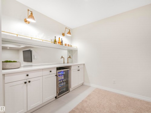 Wet bar area featuring white cabinetry, a built-in beverage refrigerator, and a mirrored backsplash - 19 Nettle Crescent, St. Albert, AB - Indoor