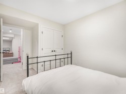 This room features light-colored carpeting and a set of white double doors with black hardware - 