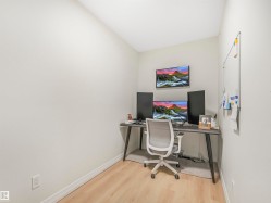 Dedicated office space featuring light wood flooring and a wall-mounted whiteboard - 