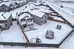 The property features a two-story exterior with dark trim detailing, a rear deck, and a fenced backyard - 