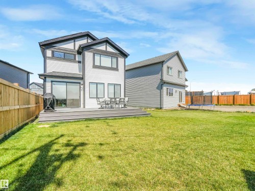 The property features a spacious backyard with a well-maintained lawn and a wooden fence - 19 Nettle Crescent, St. Albert, AB - Outdoor