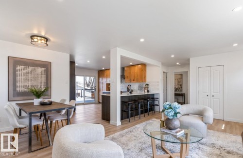 Open-concept living area featuring light wood-finish flooring, recessed lighting, and a contemporary semi-flush mount fixture - 4508 109A Avenue, Edmonton, AB - Indoor Photo Showing Living Room